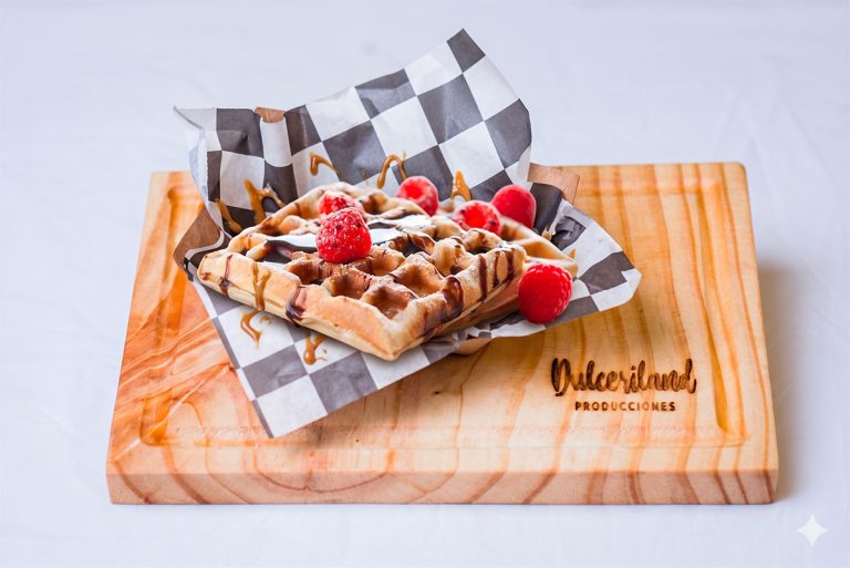 Waffles servidos con distintos toppings dulces como chocolate, frutas y salsa sobre plato de presentación