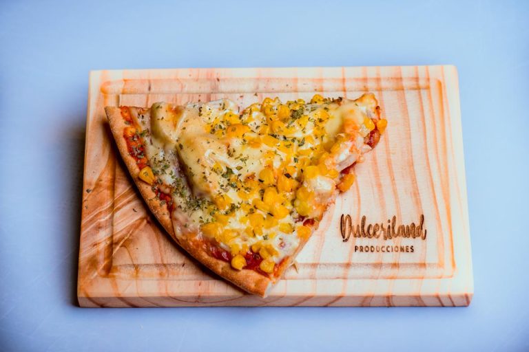 Porciones de pizza con diferentes ingredientes como jamón, queso y otros toppings sobre masa horneada