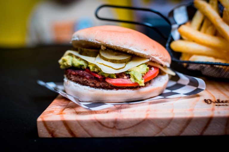 Hamburguesa con queso, tomate, lechuga y pepinillos en pan de hamburguesa